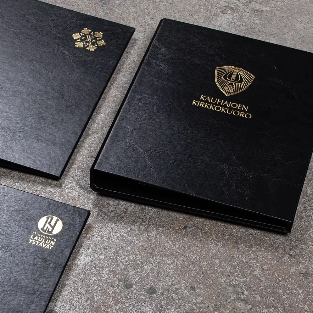 Foliopainettuja kuorokansioita.